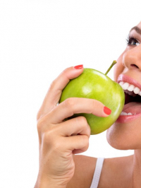 Frau isst grünen Apfel