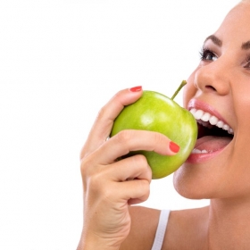 Frau isst grünen Apfel